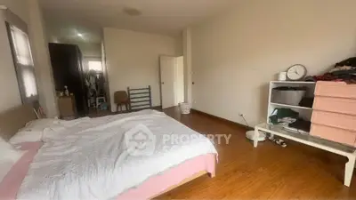 Spacious bedroom with wooden flooring and minimalistic decor