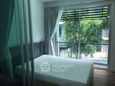 Spacious bedroom with large window and balcony view in modern apartment