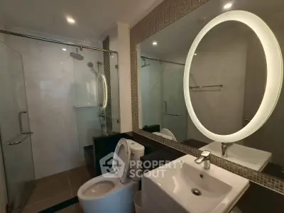 Modern bathroom with illuminated mirror and glass shower enclosure