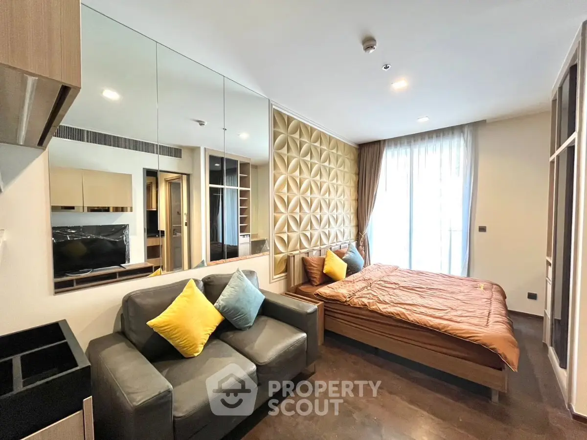 Modern bedroom with stylish decor and cozy seating area, featuring a large window for natural light.