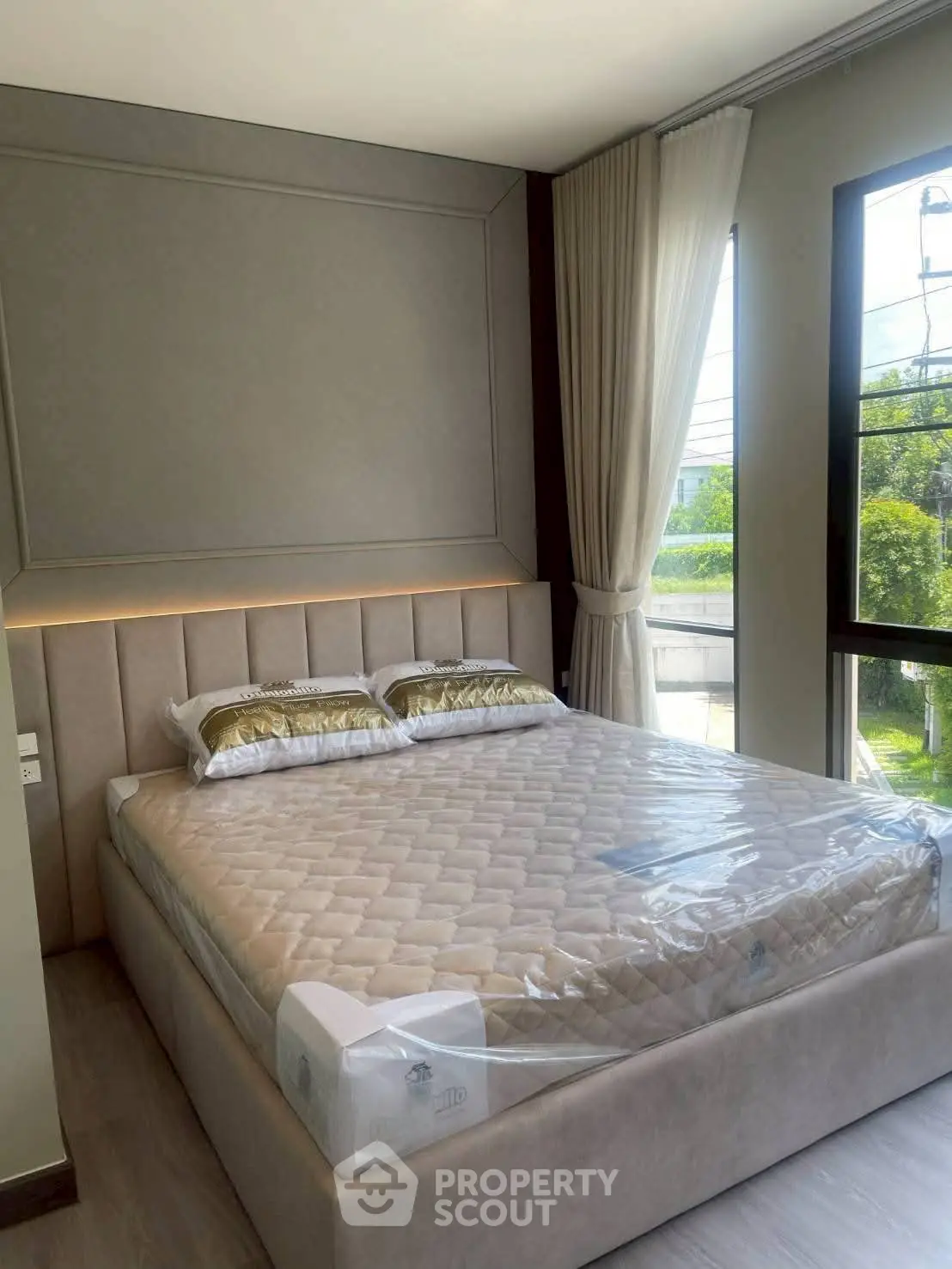 Luxurious bedroom with elegant decor and large window offering natural light.