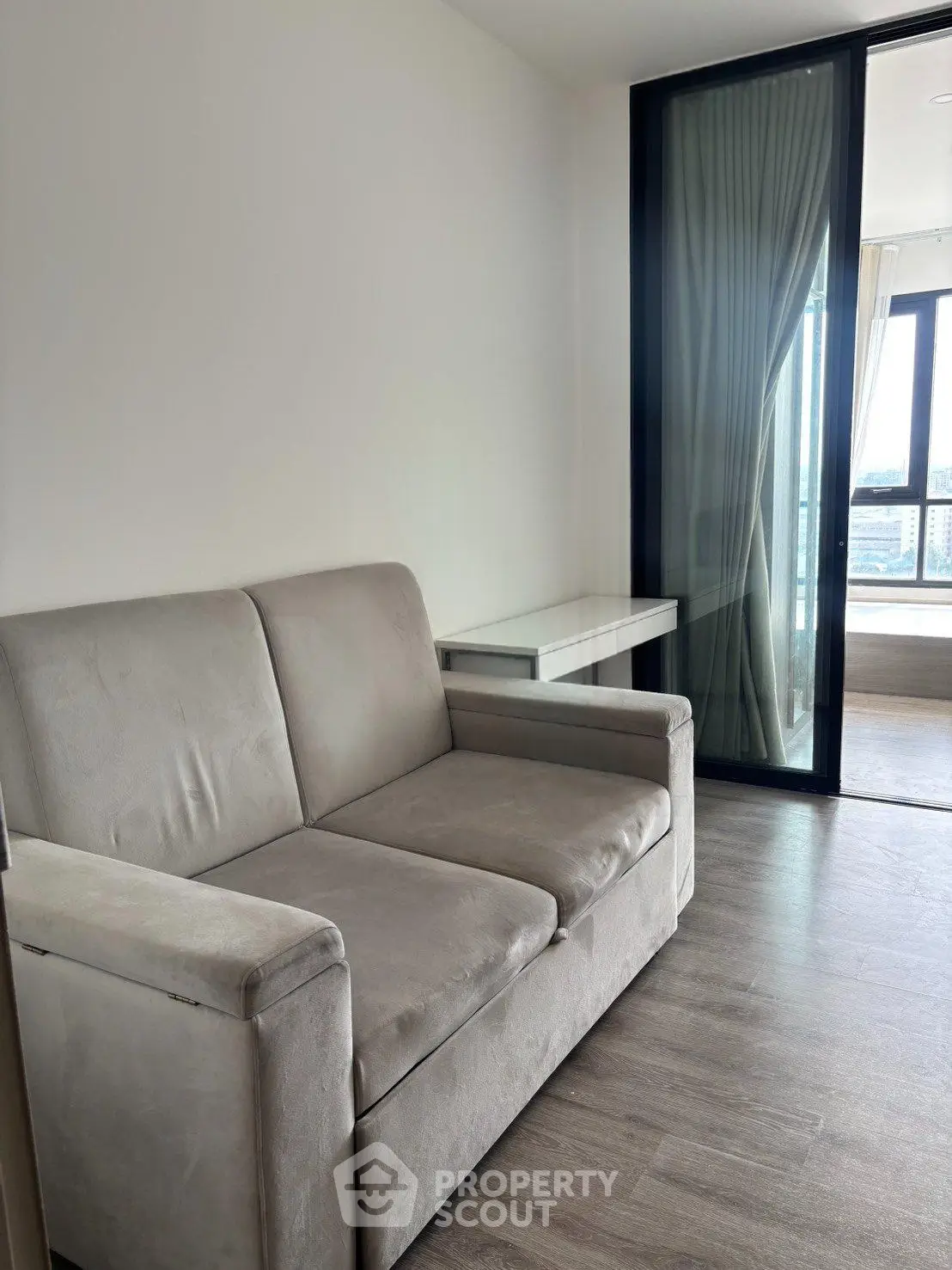 Modern living room with sleek sofa and large window offering city view