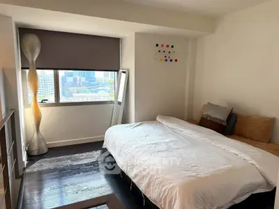 Modern bedroom with city view, featuring sleek decor and ample natural light.