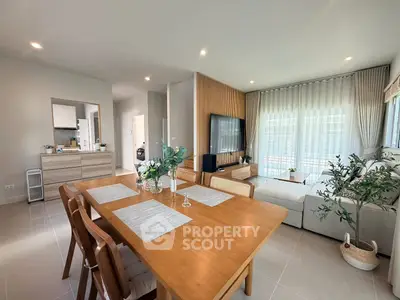 Spacious modern living room with dining area, stylish decor, and abundant natural light.