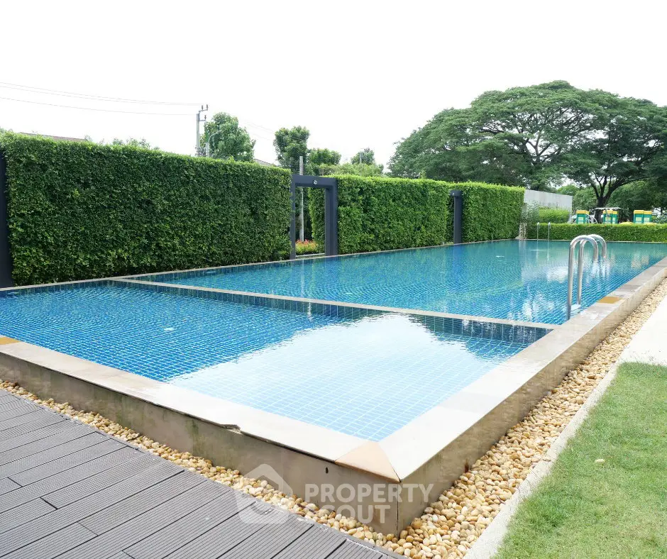 Luxurious outdoor swimming pool with lush greenery and serene ambiance