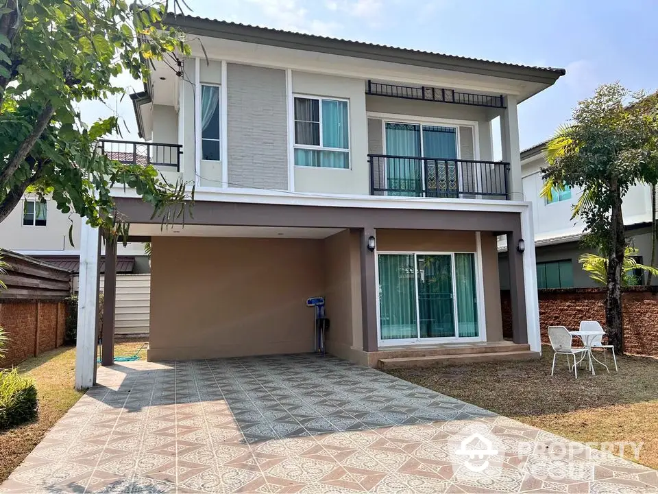 Modern two-story house with spacious driveway and small garden area.