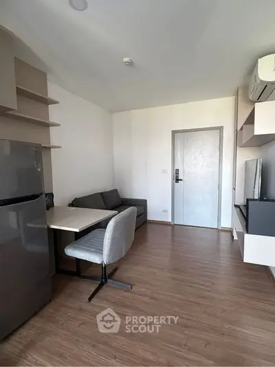 Modern living room with sleek furniture and wooden flooring in a cozy apartment.