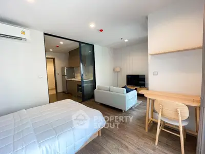 Modern studio apartment with open layout, featuring cozy living area and compact kitchen.