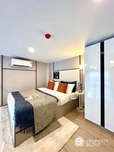 Modern bedroom with cozy decor and ample lighting in a stylish apartment.