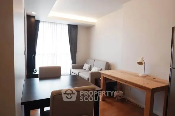 Modern living room with natural light, cozy seating, and stylish dining area in a contemporary apartment.