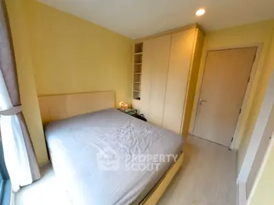 Cozy bedroom with built-in wardrobe and large window for natural light