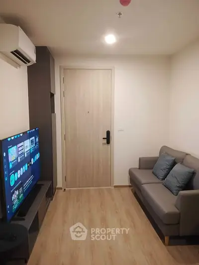 Modern living room with cozy sofa and flat-screen TV, perfect for relaxation and entertainment.