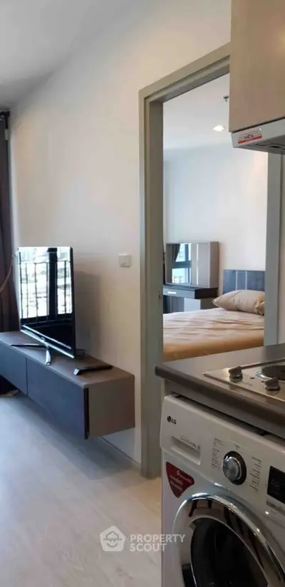 Modern apartment interior with washing machine and cozy bedroom view