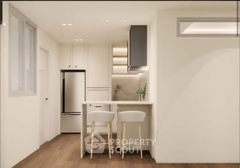 Modern kitchen with sleek design, featuring a breakfast bar and stylish lighting.