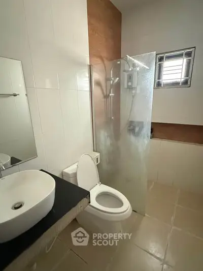 Modern bathroom with sleek fixtures and frosted glass shower in a contemporary home.