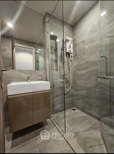 Modern bathroom with sleek design, glass shower, and stylish sink in a contemporary apartment.