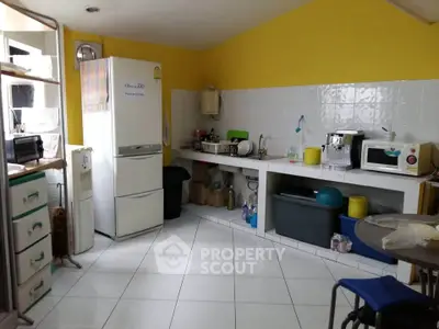 Charming kitchen with vibrant yellow walls, featuring modern appliances and ample storage space.