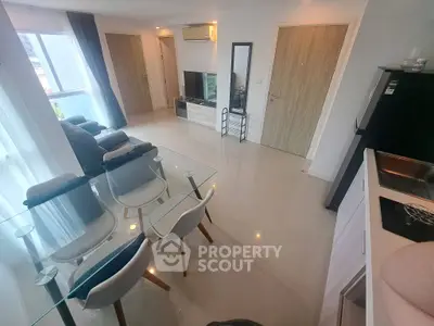 Modern living room with sleek furniture and open kitchen layout in a bright apartment.