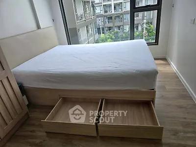 Modern bedroom with storage bed and large window offering city view