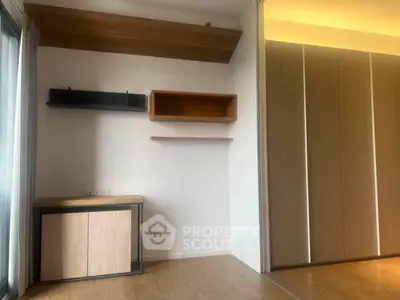 Modern minimalist interior with wooden flooring and built-in shelves, perfect for stylish living.