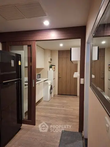 Modern kitchen with sleek appliances and wooden accents in a cozy apartment setting.