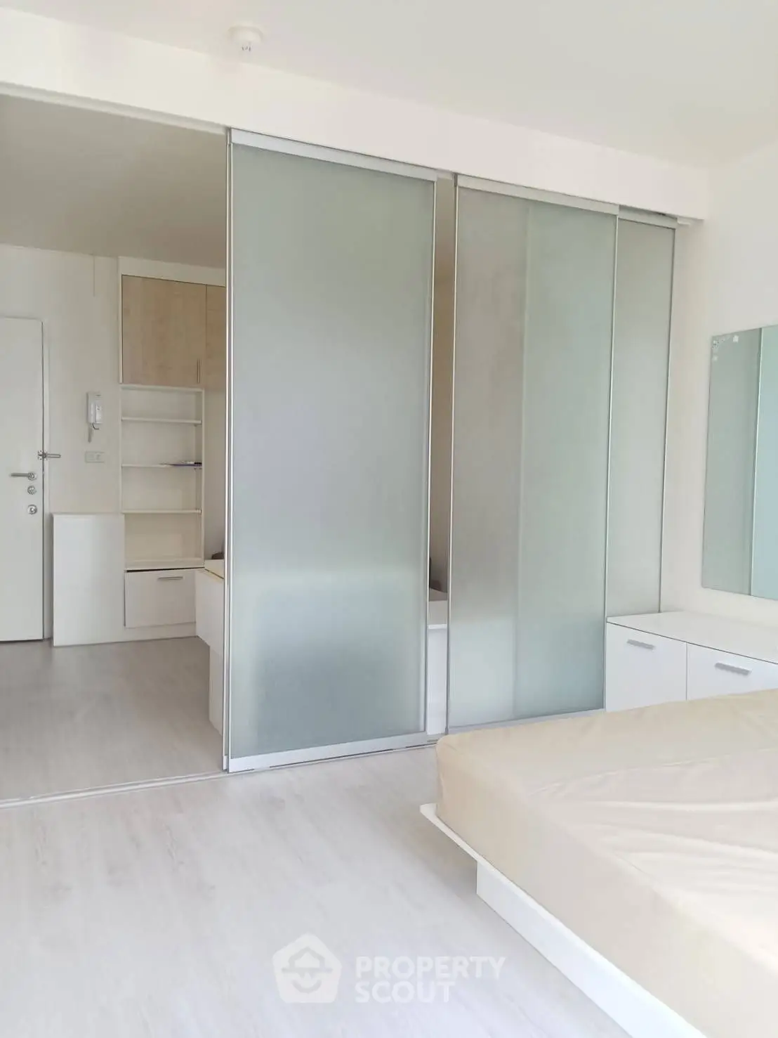 Modern minimalist bedroom with sliding glass doors and neutral decor
