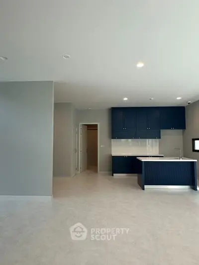 Modern kitchen with blue cabinets and open layout in a spacious apartment.