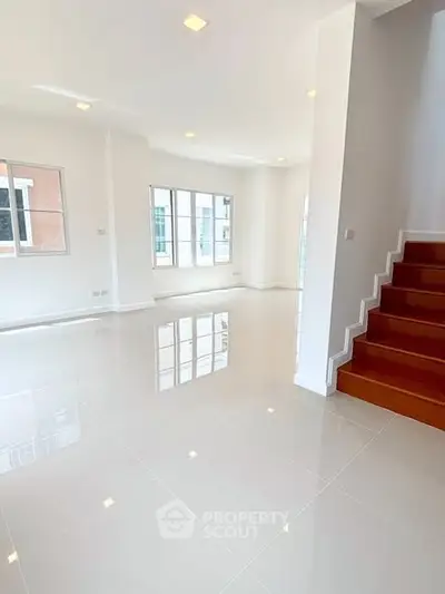 Spacious and bright living room with glossy tiled floors and large windows