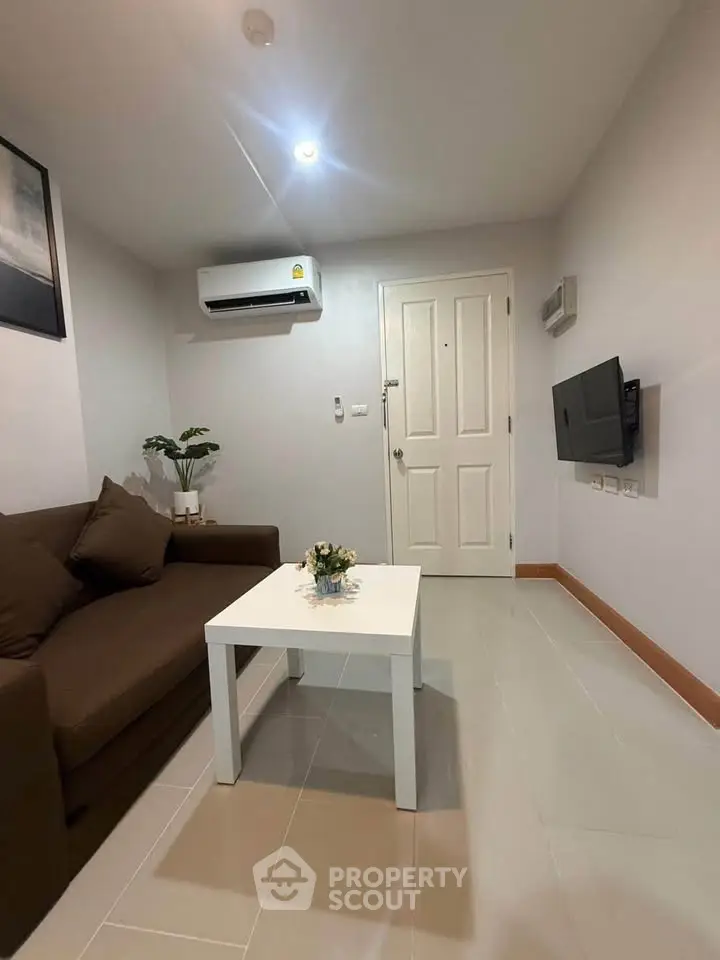 Cozy living room with modern air conditioning and wall-mounted TV, perfect for relaxation.