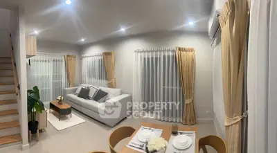 Modern living room with elegant decor and cozy dining area, featuring neutral tones and stylish lighting.