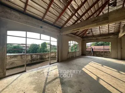 Spacious unfinished room with large windows and natural light, ideal for customization.