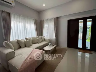 Elegant living room with cozy sofa and natural light, perfect for relaxation and entertaining.