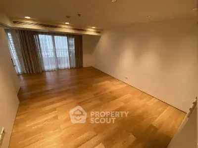 Spacious empty living room with wooden flooring and large window