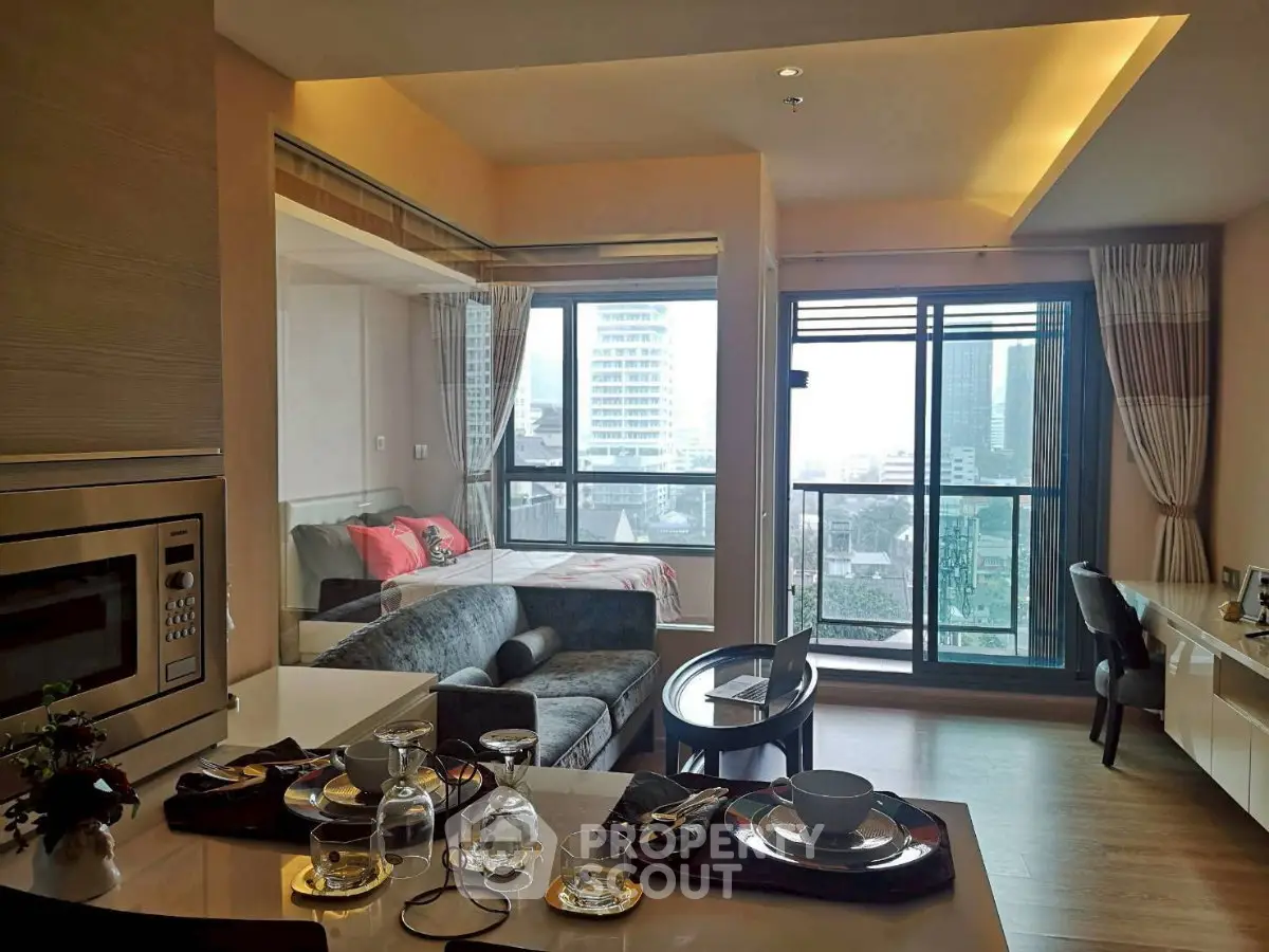 Modern open-plan living room with city view, featuring stylish decor and natural light.