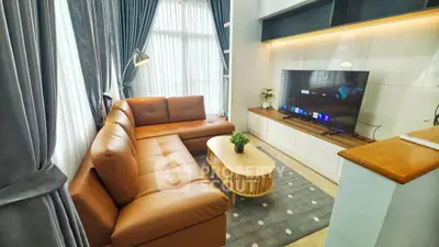 Modern living room with leather sofa, large TV, and stylish decor