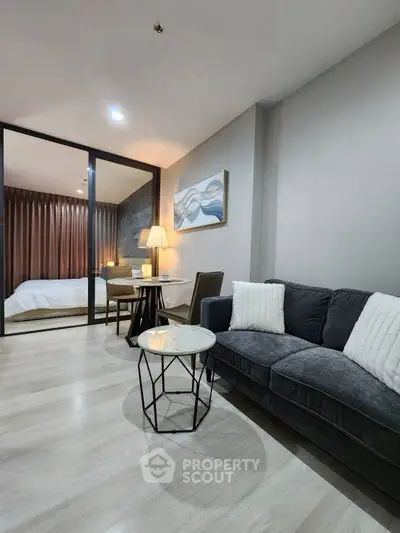 Modern living room with cozy sofa and stylish decor in open-plan apartment.