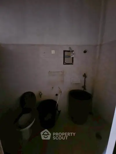 Dimly lit bathroom with basic fixtures and minimal decor.