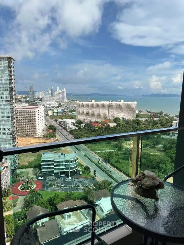 Stunning high-rise balcony view overlooking cityscape and ocean, perfect for urban living.