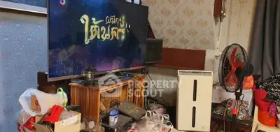 Cozy living room with TV, fan, and air purifier, showcasing a lived-in atmosphere.