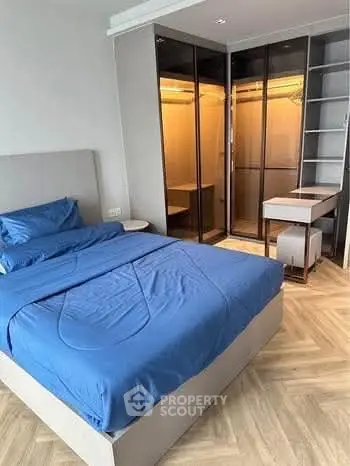 Modern bedroom with blue bedding and walk-in closet in stylish apartment