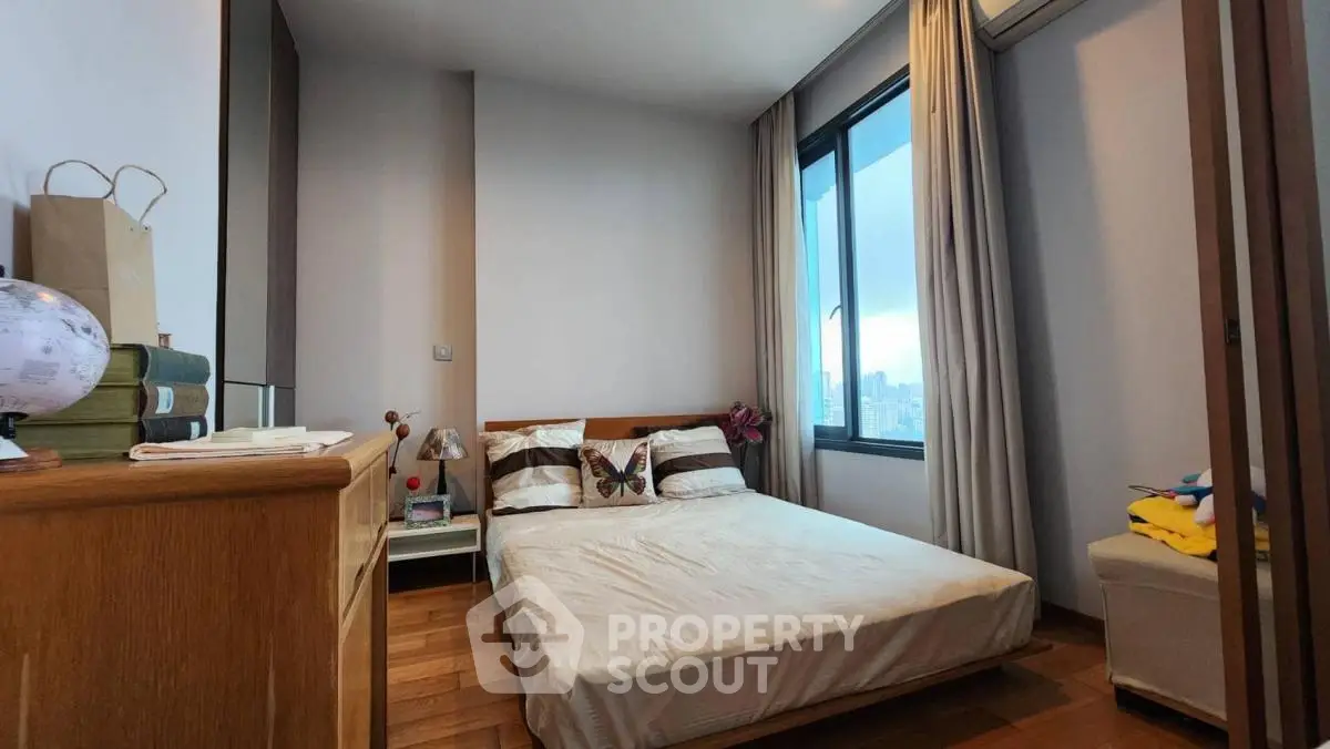 Cozy bedroom with city view, wooden flooring, and modern decor