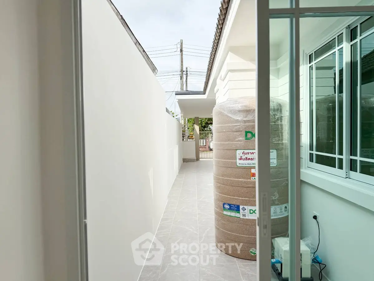 Modern exterior corridor with large water tank and sliding glass door