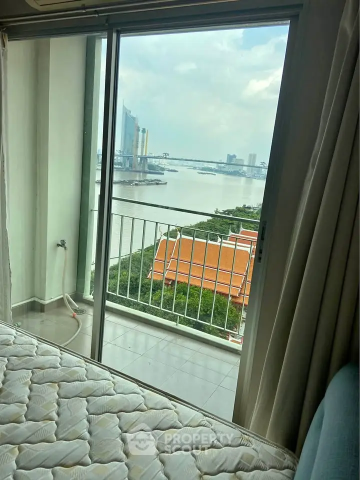 Stunning river view from a cozy bedroom with balcony access in a high-rise apartment.