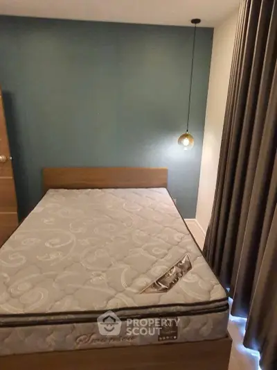 Cozy bedroom with modern lighting and elegant curtains, featuring a comfortable mattress and stylish decor.