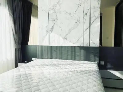 Modern bedroom with marble accent wall and natural light