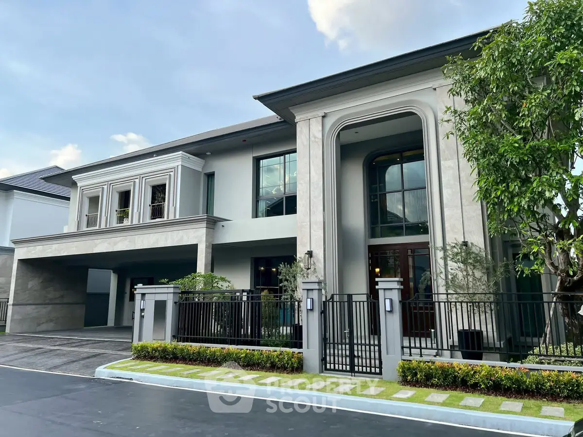 Luxurious modern house with elegant facade and spacious driveway in upscale neighborhood.