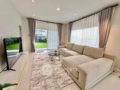 Spacious modern living room with large windows and elegant decor, perfect for relaxation and entertainment.