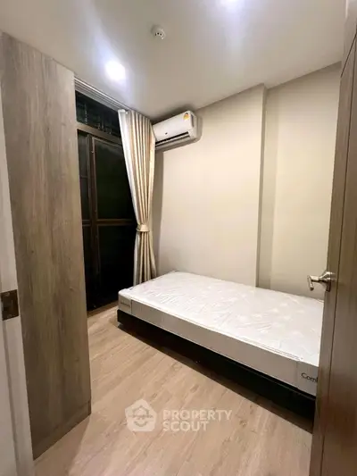 Cozy bedroom with single bed and air conditioning in modern apartment