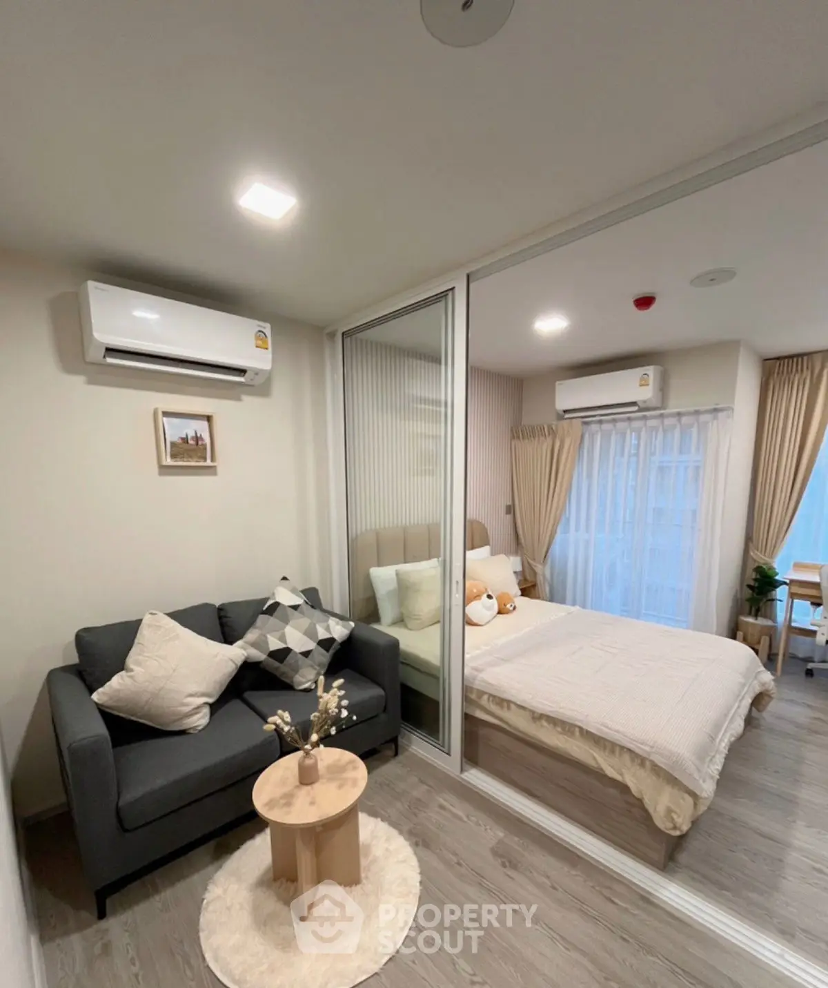 Cozy modern bedroom with stylish decor and air conditioning in a compact apartment.