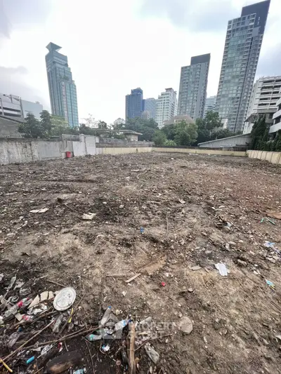 Vacant urban lot with city skyline backdrop, ideal for development opportunities.